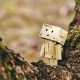 cardboard robot toy on wooden tree