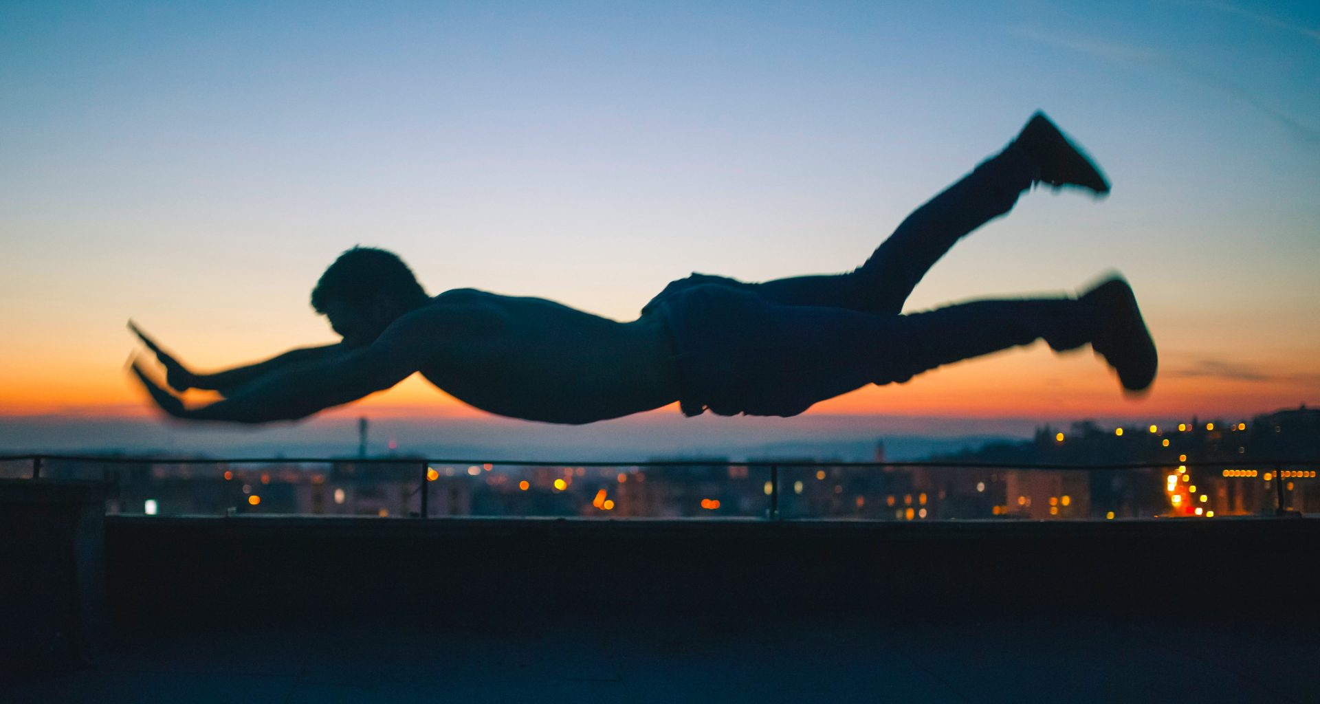 gray scale photo of man falling during golden hour