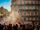 people waving flag of France near building